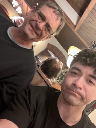 A selfie of the reviewer and another smiling person in an indoor setting.