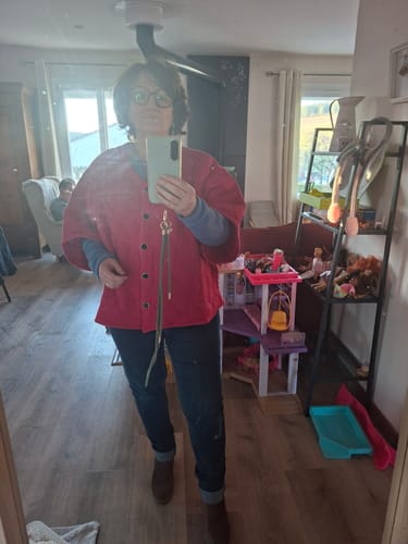 Une cliente portant la veste kimono Yoko fuchsia par-dessus un jean dans son intérieur.