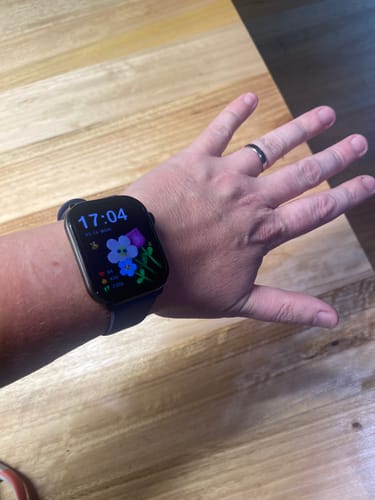 Reviewer showing their Gard Pro Health Smartwatch 3 on their wrist with a colorful floral watch face.