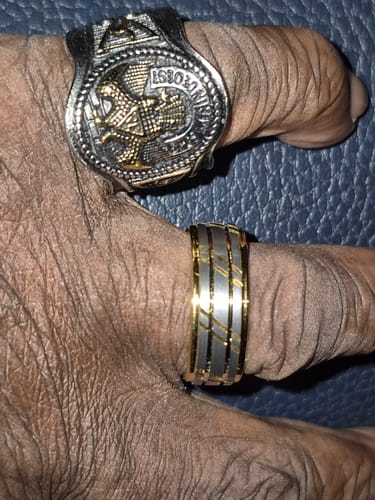 Customer's hand wearing the two-tone Bravado ring alongside another ornate ring on a different finger.