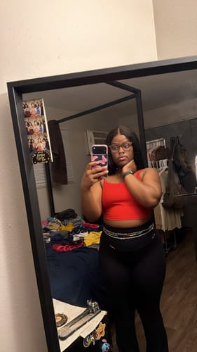 Customer taking a mirror selfie while wearing the gold and pink Rose Quartz Tie On Waist Beads.