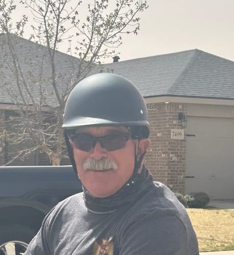 A front-view of the reviewer wearing the matte black Low Profile Polo Helmet with sunglasses.