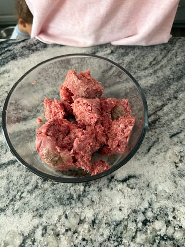 Reviewer's Angus Ground Beef broken up in a clear glass bowl on a kitchen countertop.