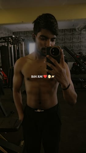 Reviewer taking a mirror selfie in a gym, showing their defined physique after using Wellcore creatine.