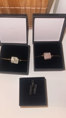 Avis d'un client : le bracelet en quartz rose brut dans sa boîte, à côté d'un autre bijou et d'un pendentif.
