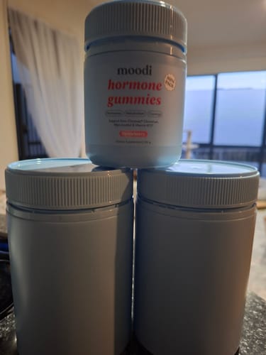 Customer's three jars of Hormone Gummies, with the Strawberry flavor stacked on two others on a counter.
