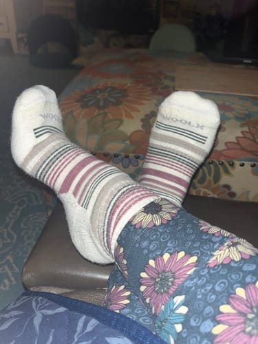 Reviewer showing how their striped Everyday Crew Socks coordinate with a pair of floral leggings.