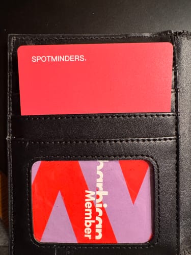 Customer's red SPOTMINDERS tracking card shown partially inserted into a black wallet.
