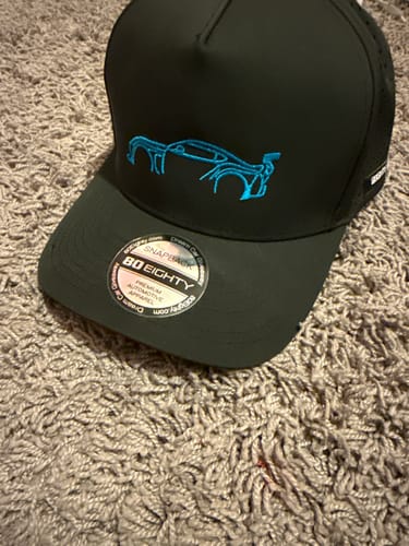 Customer's black 80Eighty DCG#87 hat on a carpet, showing the blue embroidered car on the front panel.