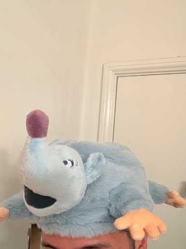 Customer wearing the light blue, plush Lester's Possum Pal hat from A Goofy Movie on their head.