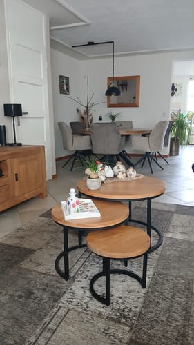 Een klant toont de Salontafel Dakota set van drie in een woonkamer, geplaatst op een vloerkleed.