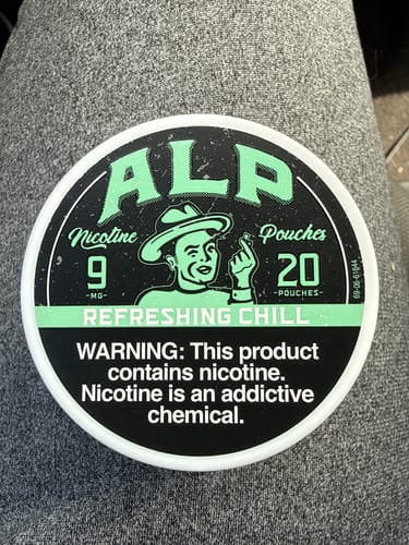 Customer's close-up of the circular tin of ALP Refreshing Chill Nicotine Pouches.