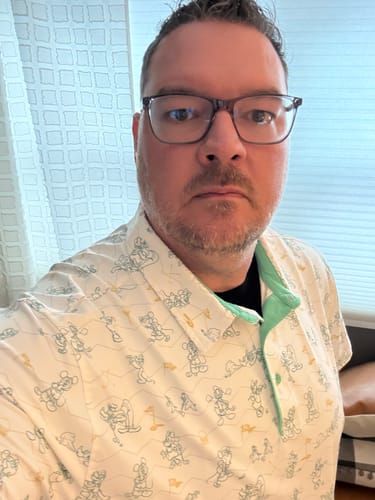 Customer showing the fit of the Disney "Mickey's Fairway Friends" polo with its sketch-style pattern.