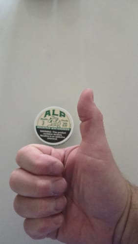 Reviewer gives a thumbs-up in front of their can of Mountain Wintergreen Nicotine Pouches.