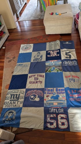 Reviewer's custom Project Repat T-Shirt Quilt made with New York Giants shirts, spread out on a floor.