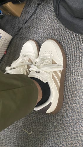 Customer wearing the adidas Men's Courtblock Casual Shoes, showing the white and beige side profile.