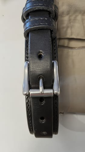Customer's .75" nickel roller buckle fastened onto a thick black leather belt.