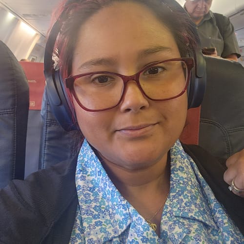 Reviewer wearing the blue floral Bloomshakalaka shirt while seated on a plane.