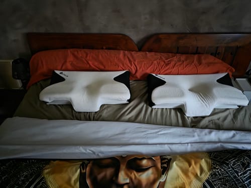Deux coussins d'alignement cervical Cellsius d'un client, placés côte à côte sur un lit.