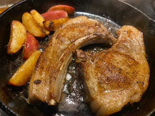 Customer pan-frying pork chops rubbed with Cool Hog's Maple Seasoning in a skillet.