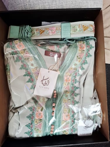 Customer's Floral Mint kaftan and matching belt packaged in a box, showing the detailed embroidery.