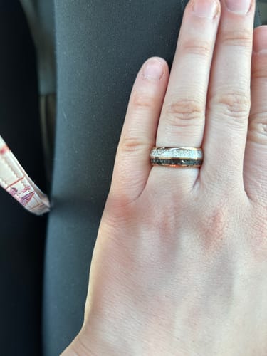 Reviewer's hand wearing the Ferox ring, showing its textured meteorite inlay and rose gold finish.