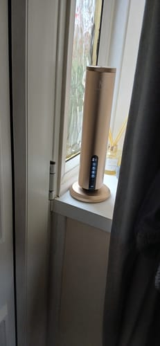 Reviewer's gold LumaMax diffuser turned on and placed on a white windowsill.