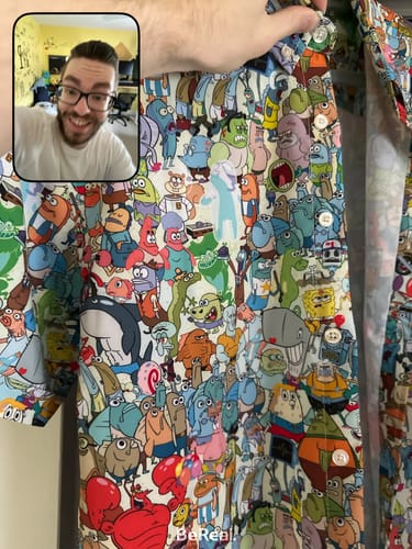 Reviewer's close-up of the colorful SpongeBob 'Welcome to Bikini Bottom' shirt, showing off the detailed all-over character print.