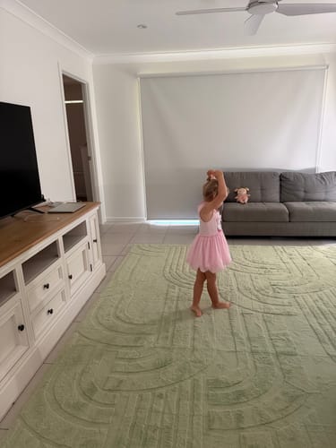 Customer's child practices ballet on the large Pistachio Green Mellow Mat in a living room.