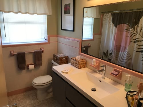 Reviewer's Monterey Floating Vanity installed in a vintage bathroom with pink and white tile.