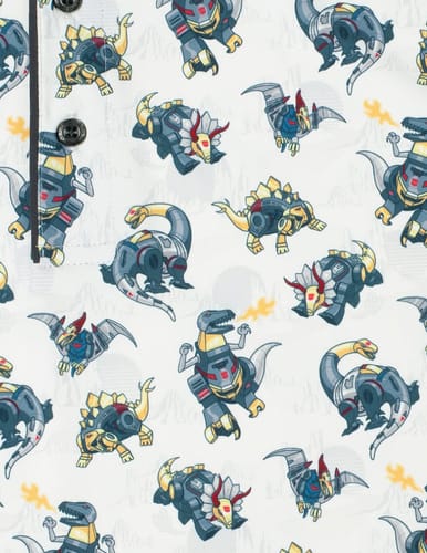 Reviewer's close-up of the Transformers 'Dino Might' polo shirt, showing the colorful cartoon Dinobot pattern on the white fabric.