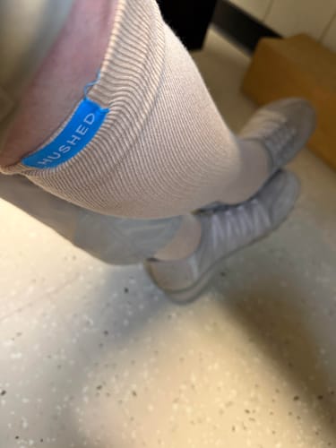 Customer wearing the tan Performance Eucalyptus Compression Socks, with a close-up on the ribbed top cuff.