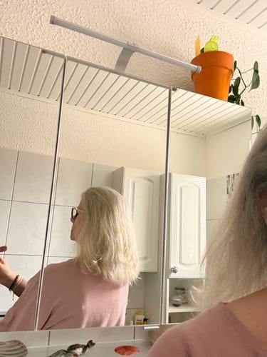 Rezensentin zeigt ihr helles, weiches Haar im Spiegel nach der Verwendung der Apple-Wonder Haarseife.