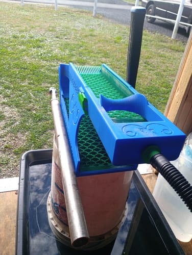 Customer's blue Switchback Clean-Up Sluice Box Kit with a green mat, set up on a bucket outdoors.