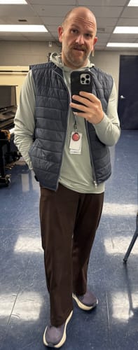 Reviewer wearing the light-colored Thunder Frost Performance Hoodie layered under a vest for a casual workday.