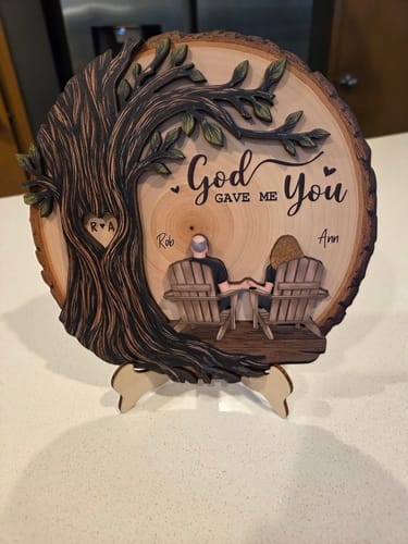 A customer's personalized 2-layered wooden plaque on a stand, showing a couple under a tree with the names 'Rob' and 'Ann'.