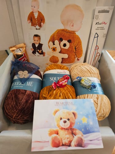 Customer's 'Baby Boy Every Month' knitting kit unboxed, showing soft wool, baby patterns, and knitting accessories.