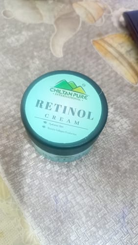 Reviewer's ChiltanPure Retinol Cream jar with a teal lid, seen from above on a textured surface.