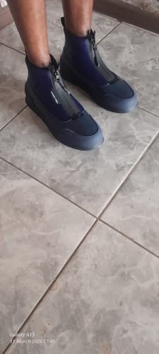 Customer wearing the navy Mazerata Valentino 20 zip-up sneakers on a tiled floor.