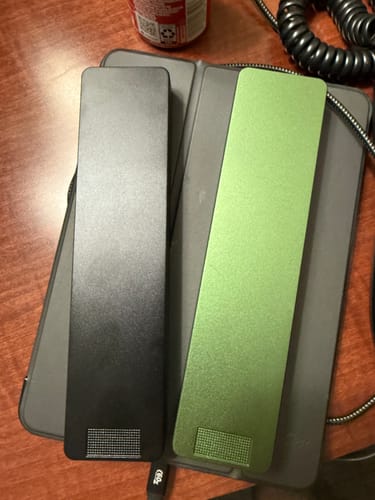 Customer's black and green metal pill cases from the 2-pack bundle shown on a desk.