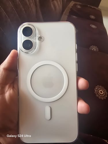 A customer's hand holding a white iPhone 16 Plus with the Anti Yellow Magsafe Clear Case, showing the white magnetic ring.