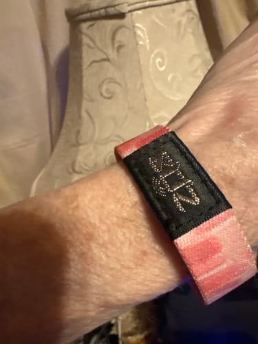 Close-up of a reviewer wearing the pink and black God Is Within Her Bible Verse Bracelet on their wrist.