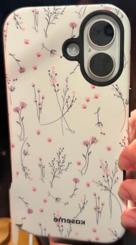 Reviewer holding their phone with the Courage Pink case, featuring a dainty, pink floral pattern.