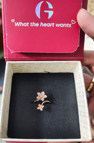 Reviewer holding open a presentation box showing the sparkling Rose Gold Blooming Flower Ring.