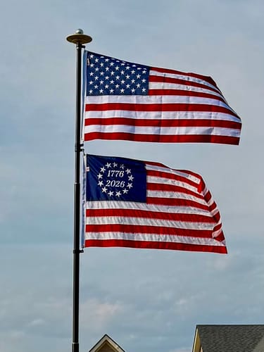Reviewer's 1776 to 2026 Betsy Ross Flag flying on a flagpole below an American flag.