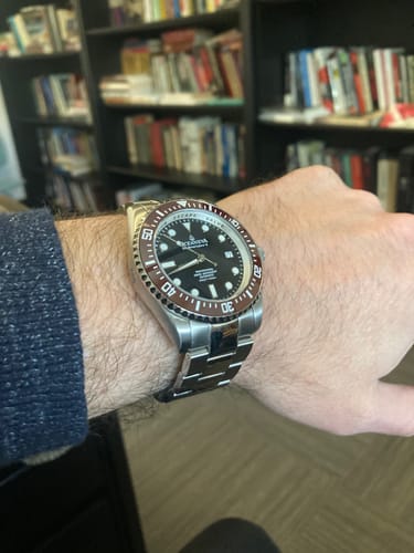 Reviewer's wrist wearing the Oceaneva Deep Marine Explorer II watch, showing its brown bezel and stainless steel band.