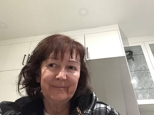 A customer showing her brown, shoulder-length hair after using the shampoo for thicker volume.