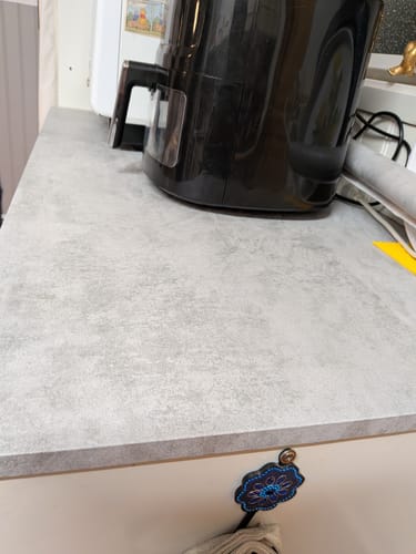 Kundens kjøkkenbenk dekket med grå, teksturert mikrosement kontaktplast.