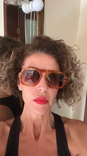 Avaliadora em uma selfie de rosto, usando os óculos Cagliari com armação de animal print.