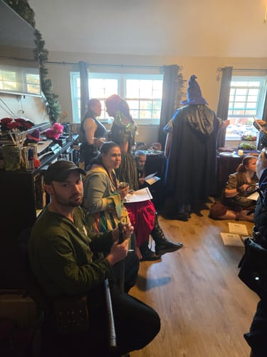 Reviewers playing the Fantasy Medieval Themed Murder Mystery game, some dressed in character costumes inside a home.